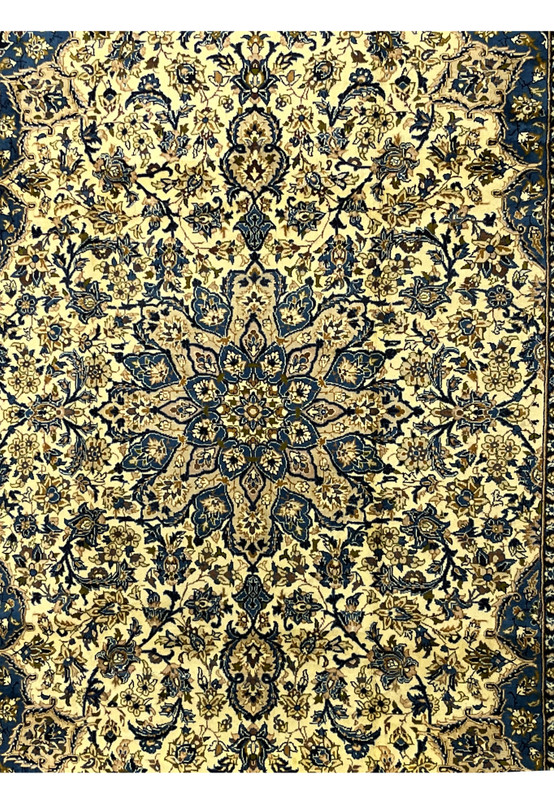 Central medallion detail of Persian Kashan rug in navy and gold tones layered floral rosettes on ivory ground
