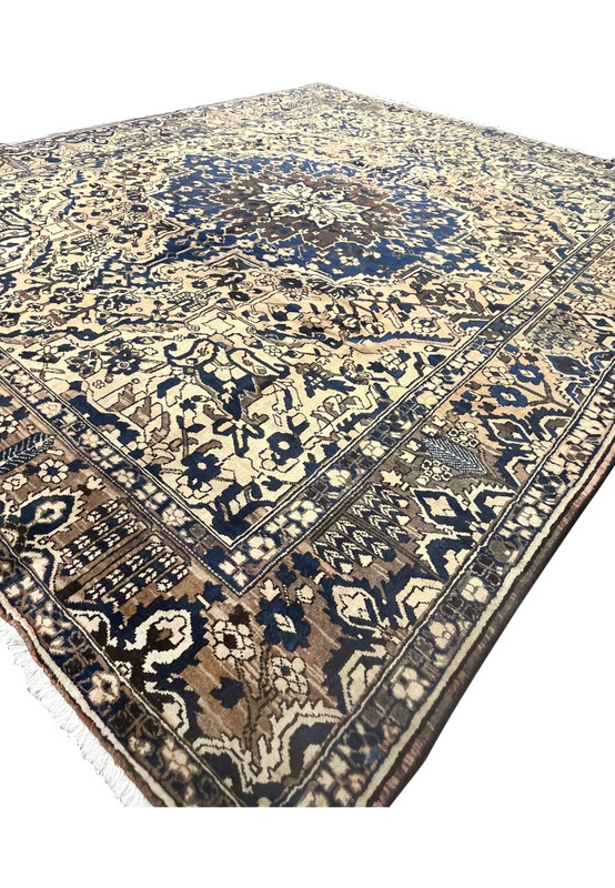 Low angle view of large geometric Persian Heriz rug in muted navy blue and ivory with classic tribal border pattern