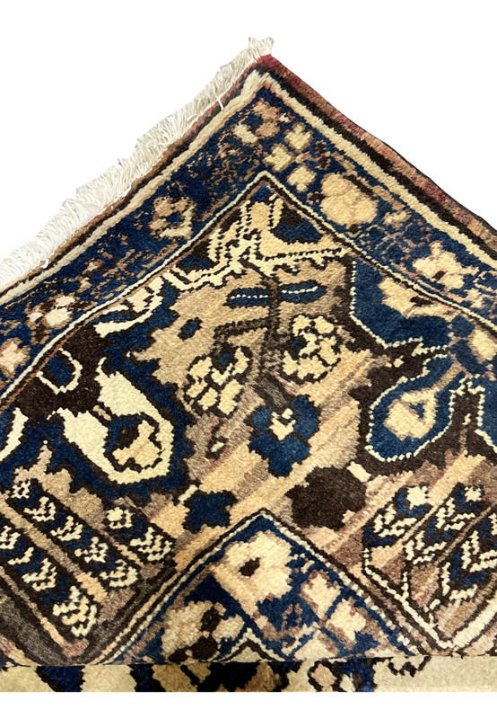 Folded corner detail of 11x13'3 Vintage Persian Heriz rug revealing dense weave, navy blue border and ivory geometric design