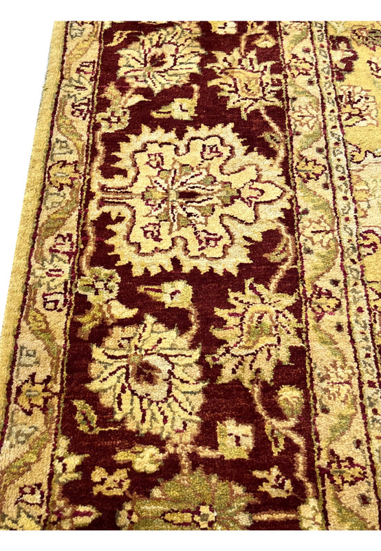 Detailed border closeup of 9x12 gold Agra rug highlighting floral vines and wool texture