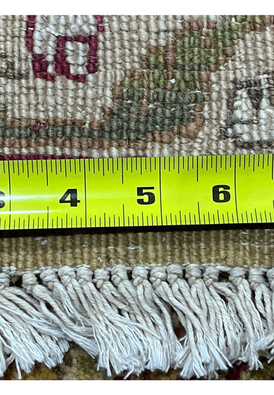 Back of 9x12 gold Agra rug with measuring tape showing knot detail, cotton foundation and tight handmade construction.