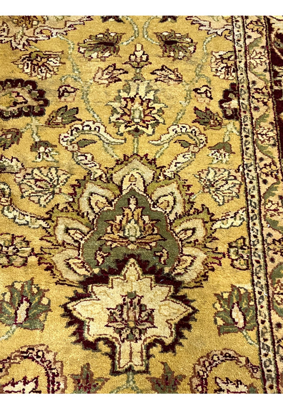 Detailed pattern section of 9x12 gold Agra rug featuring symmetrical floral elements and scrolling vines on warm mustard background.