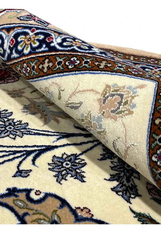 Foundation closeup Persian Isfahan wool silk rug folded edge showing cotton base pile thickness navy border