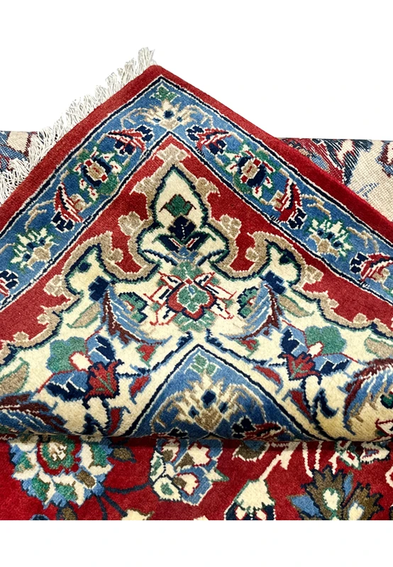 Folded edge detail 8x12 Persian Isfahan wool rug showing hand knotted construction pile depth ivory border crimson field