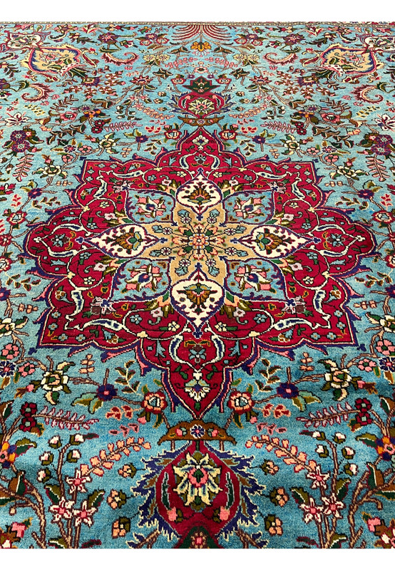 Central medallion closeup on 10x13 Persian Tabriz rug, eight-lobed crimson and ivory star on sky blue