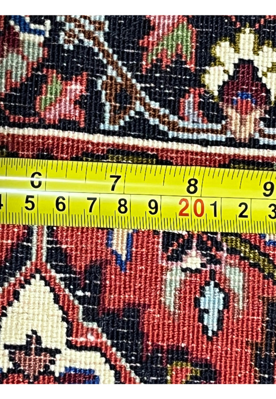 Back of authentic Persian Bijar rug measured with ruler, showing dense hand-knotted density