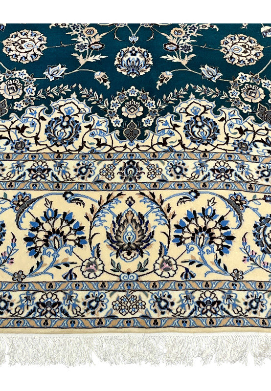 Ivory main border with blue palmettes and vine scrolls flanking the emerald green field