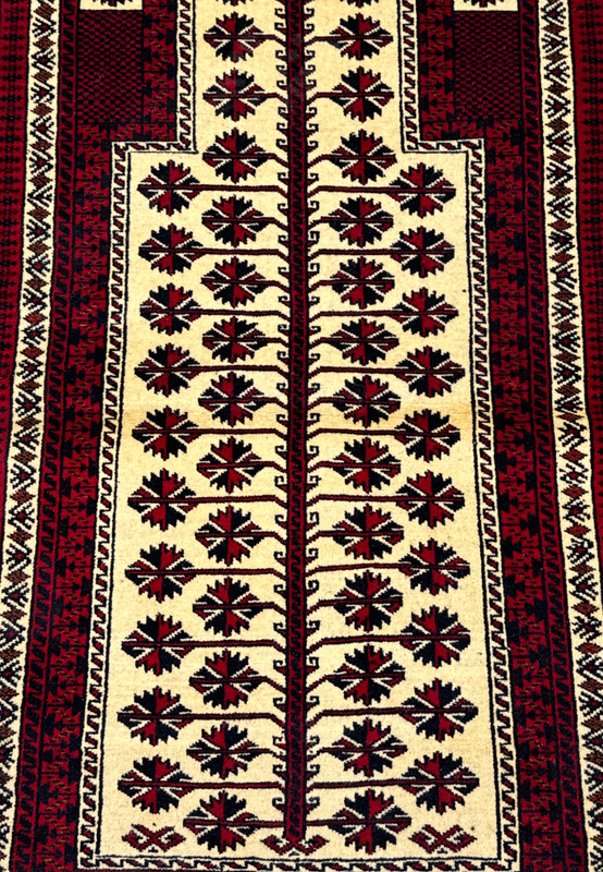 Ivory mihrab field of Baluch prayer rug showing tree of life with geometric star blossoms in red and black