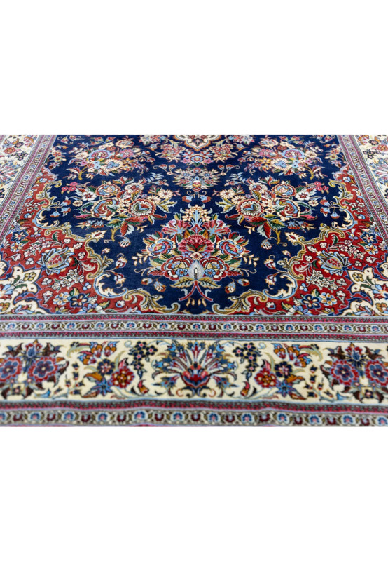 Lower field of Persian Qum kork rug showing brick red corner spandrel and floral vase bouquet motif