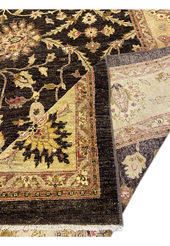 Folded corner of Agra rug showing black field, gold border, and red minor guard stripe transition