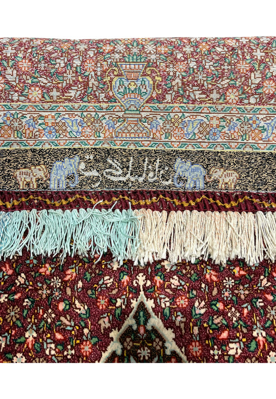 Reverse view of the woven Gholbafan signature flanked by camel and elephant trademark figures