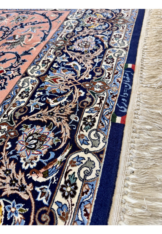 Lower border detail with rosette palmettes, scrolling acanthus, and a flag and signature cartouche meeting the navy field at the rug edge