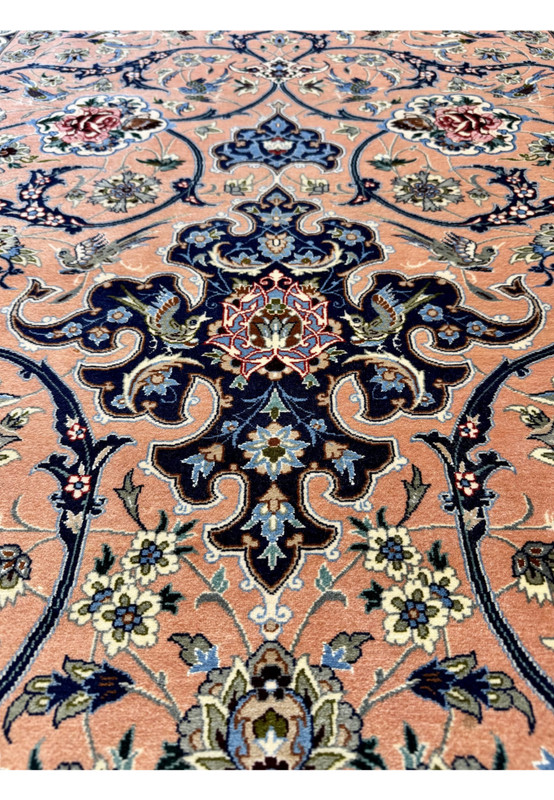 Center axis detail of the upper indigo cartouche anchor with paired birds, palmette infill, and a small ruby rosette at the heart of the design