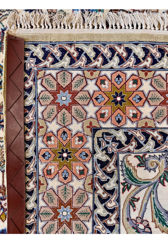 Backside view of the corner showing knot precision on the silk foundation with the star and rosette border motifs reading clearly from the underside