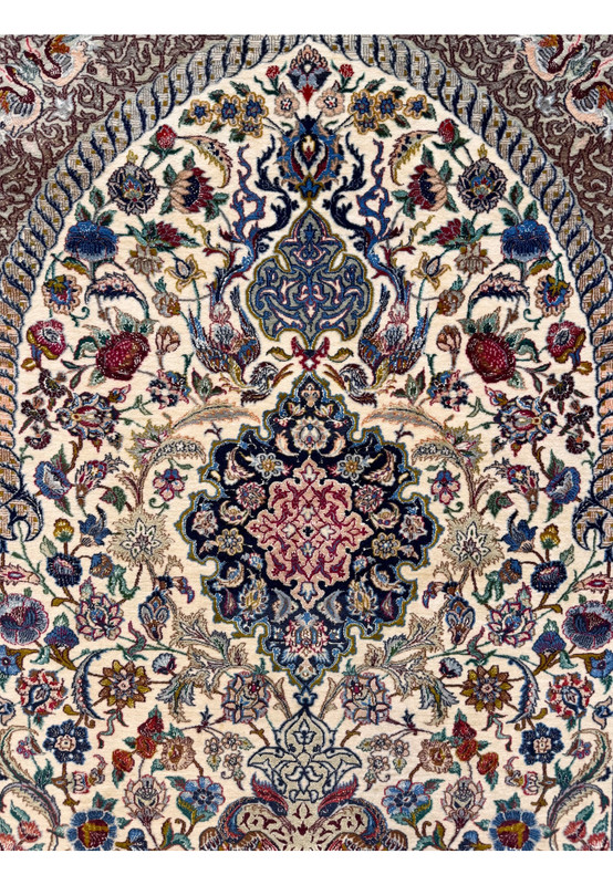 Upper field detail showing the tall ivory mihrab arch rising from the central medallion filled with vines, palmettes, and ground birds