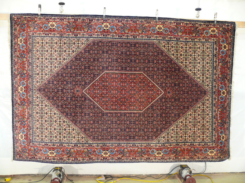 Hanging full view of 7x10 Persian Bijar rug showing complete diamond medallion design and ornate main border