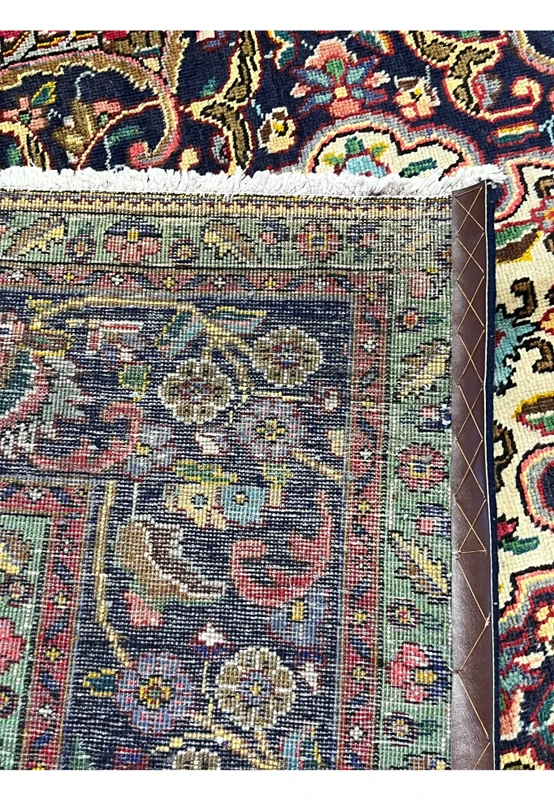 Backside corner of authentic Persian Kerman rug showing hand-knotted construction, dense weave structure, and natural ivory cotton fringe