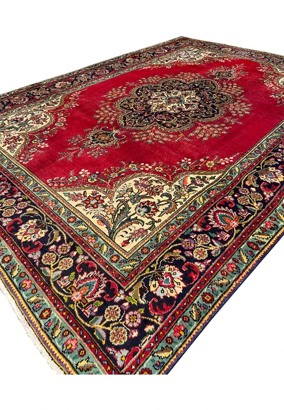 Three-quarter angled view of authentic handmade Persian Kerman rug for formal living room with ivory corner spandrels and floral bouquets