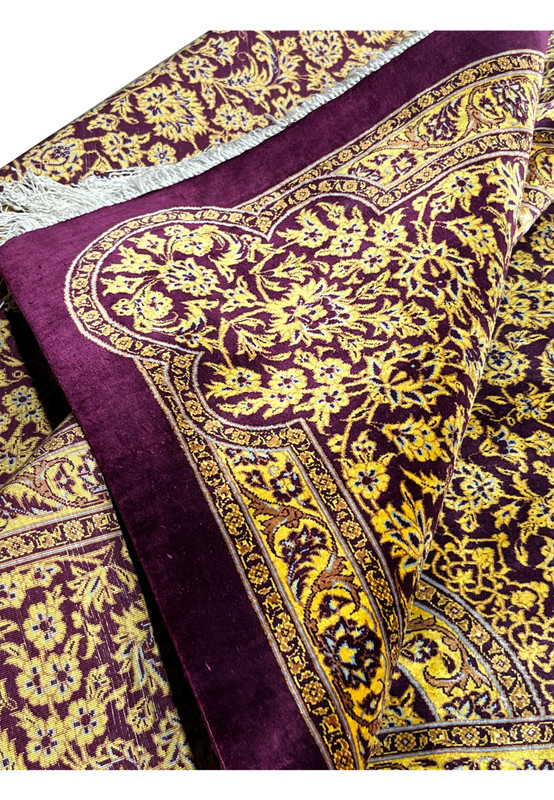 Folded corner of 7x10 Naimi Persian Qum pure silk rug, fringe and selvage visible alongside gold and magenta border work