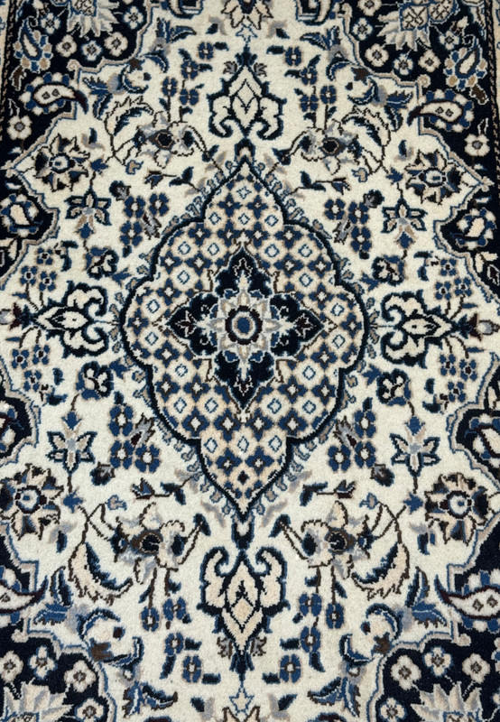 Close detail of central diamond medallion on 3x5 Nain rug, eight point star core surrounded by finely woven trellis fill