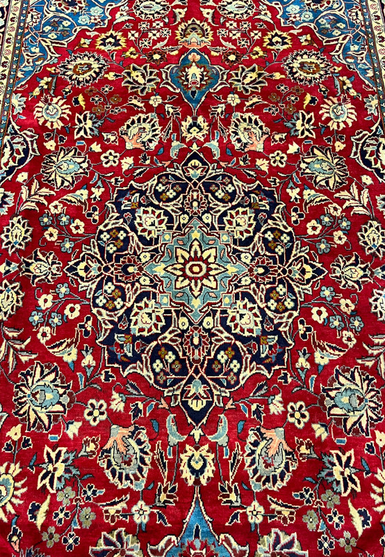 Central layered medallion detail of Persian Najafabad rug, eight point starburst rosette on navy core with ivory cusped lobes