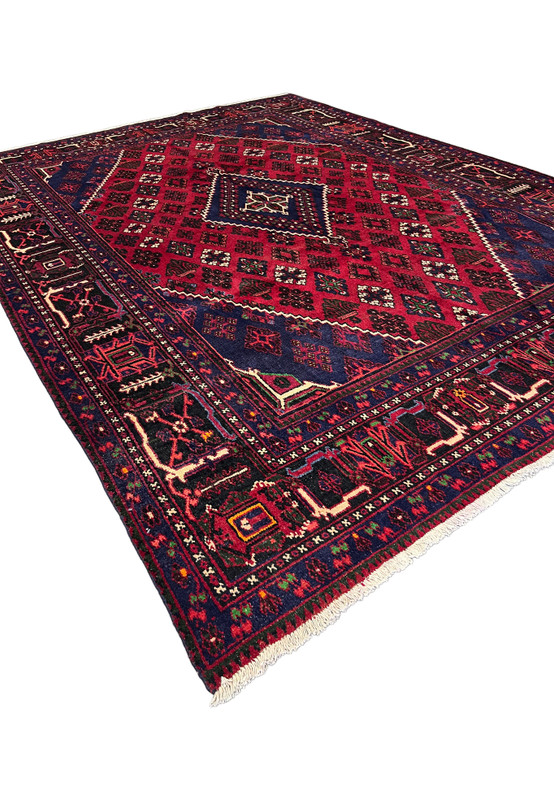 Angled view of 10x13 Meymeh rug from the corner, navy spandrels and red field, hand-knotted wool, for great room