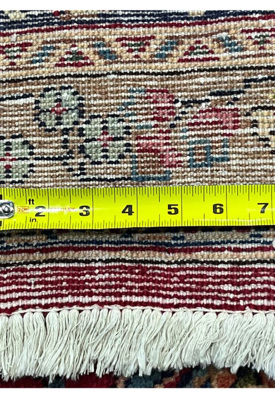 Backside knot density measured on Persian Mashad rug, ruler showing tight knot count, 180 to 200 KPSI hand-knotted wool