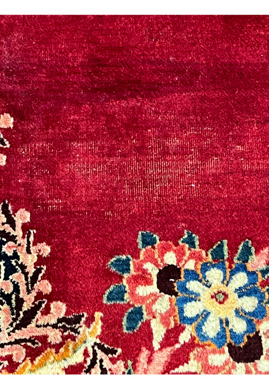 Abrash close-up on red field of antique Persian Moud rug, natural dye lot variation, fingerprint of authentic traditional weaving
