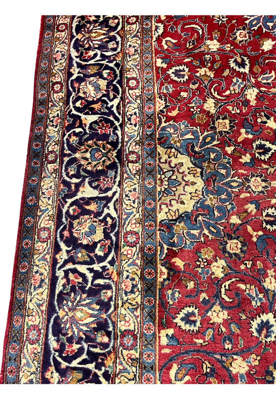Border closeup Persian Isfahan rug, palmette and vase motifs on saturated indigo, fine wool pile on cotton foundation handmade in Persia