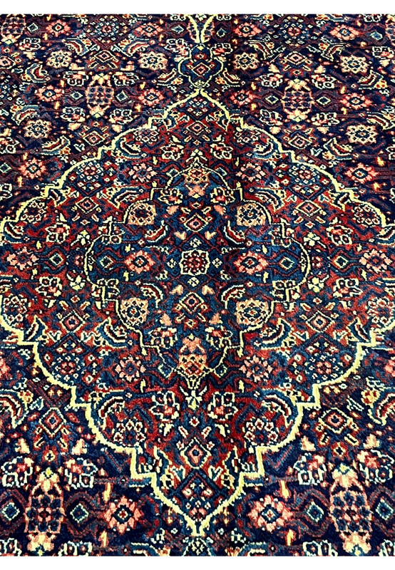 Central medallion of Persian Sarough rug, ivory diamond cartouche on dense navy floral field, authentic hand-knotted workshop weave