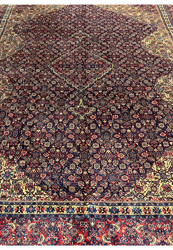 Midfield detail Persian Sarough rug, dense small-scale floral lattice with salmon boteh on saturated navy ground, hand-knotted