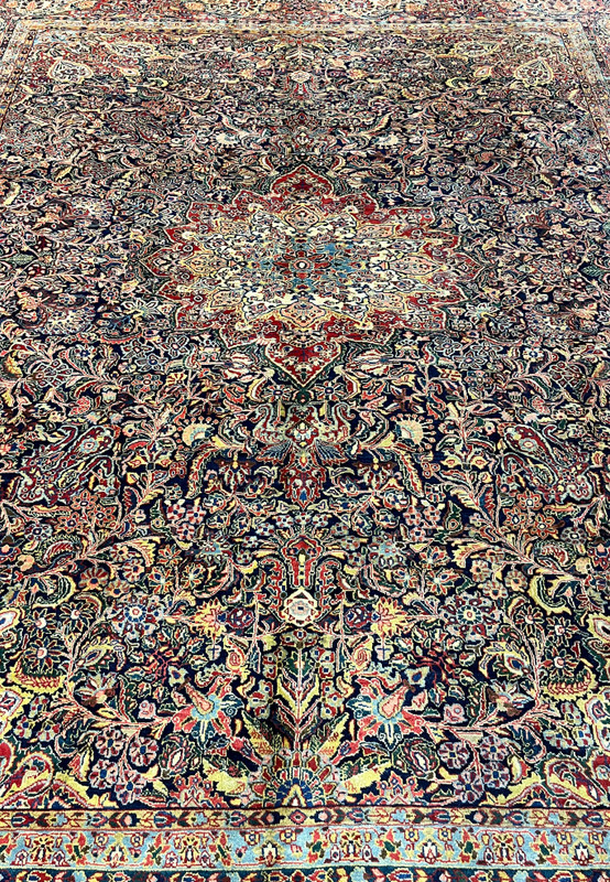 Hand-knotted antique Sarough rug midfield close-up showing dense navy ground with palmette and rosette florals