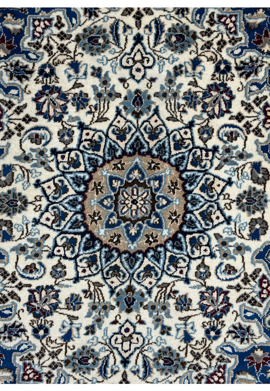 Camel center medallion close-up of authentic Persian Nain rug, sky blue and navy stepped cartouches on ivory ground