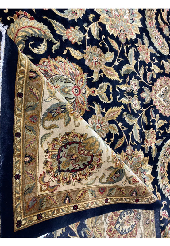 Midfield detail of oversize midnight blue Jaipur rug, large palmettes and leafy vinework on inky blue ground