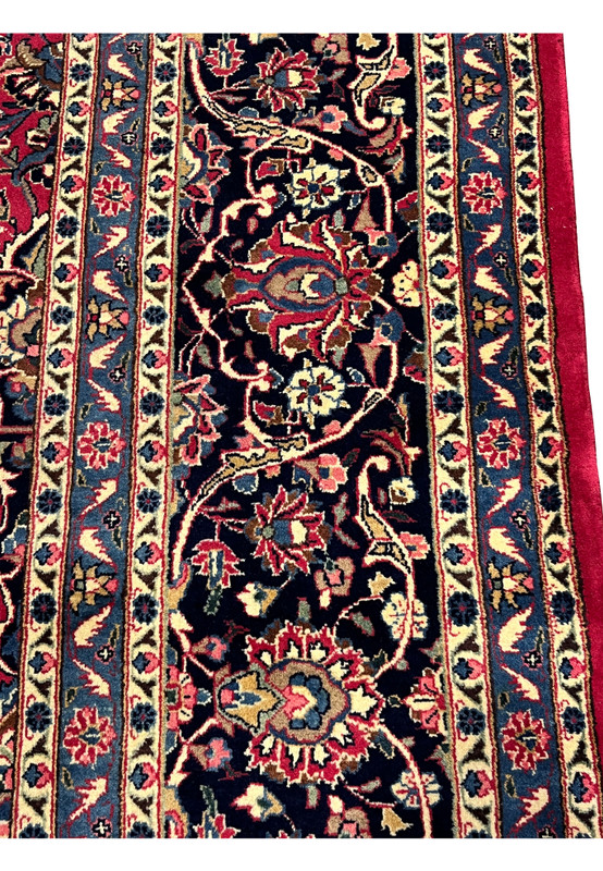Border close-up of authentic Mashad rug, navy palmette and vine band framed by sky blue and ivory guards