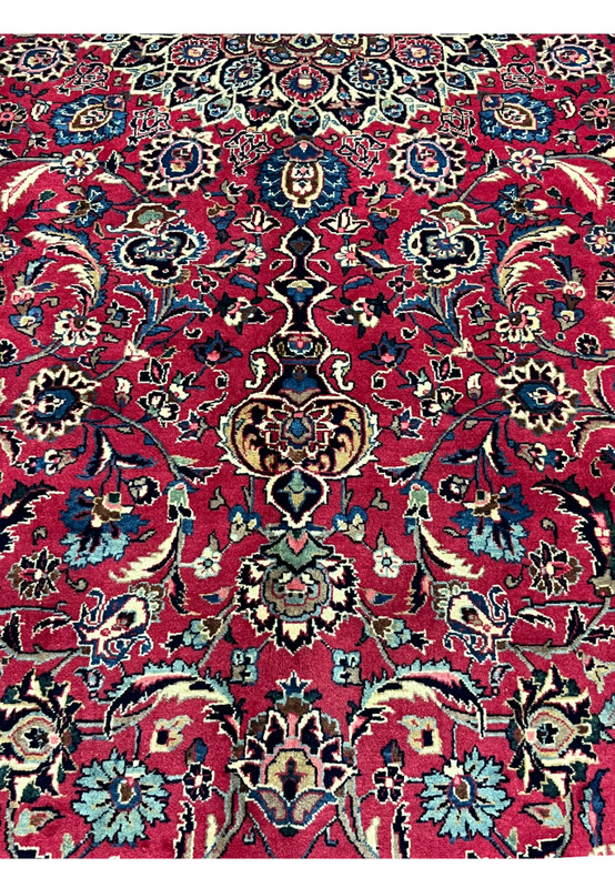 Color and pattern close-up of Persian Mashad rug, cherry red field with navy and sky blue floral motifs