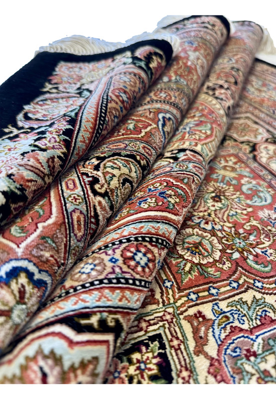 Rolled view of Hossein Kashizadeh pure silk Qum rug, lustrous silk pile and fine border along the roll