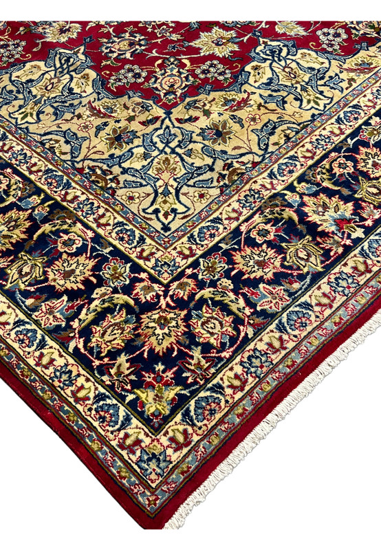 Edge and corner of hand-knotted wool Najafabad rug with cream spandrel and navy floral main border