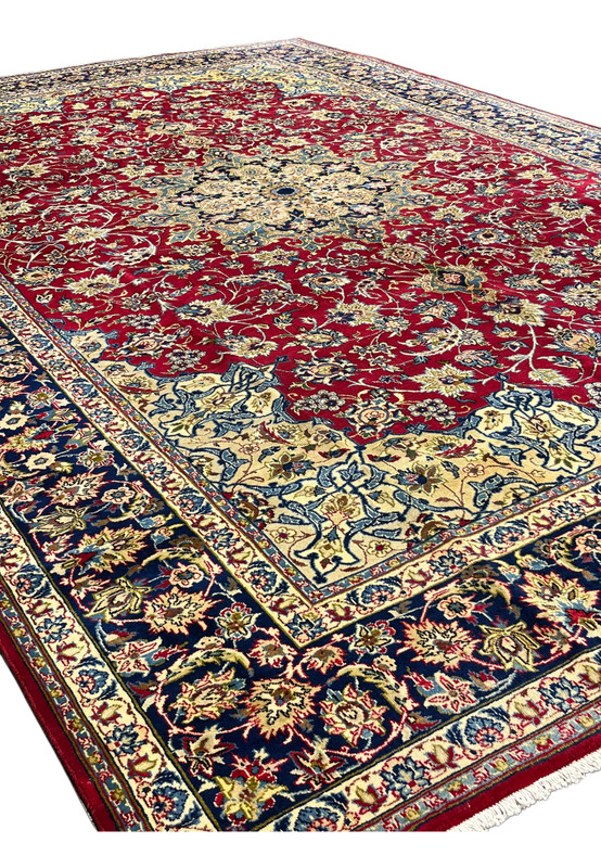 Angled view of authentic Persian Najafabad rug showing red field, cream medallion, and border depth