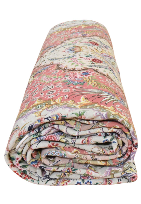 13x20 Persian Tabriz rug rolled, showing the chiffon-white field and fine wool and silk pile