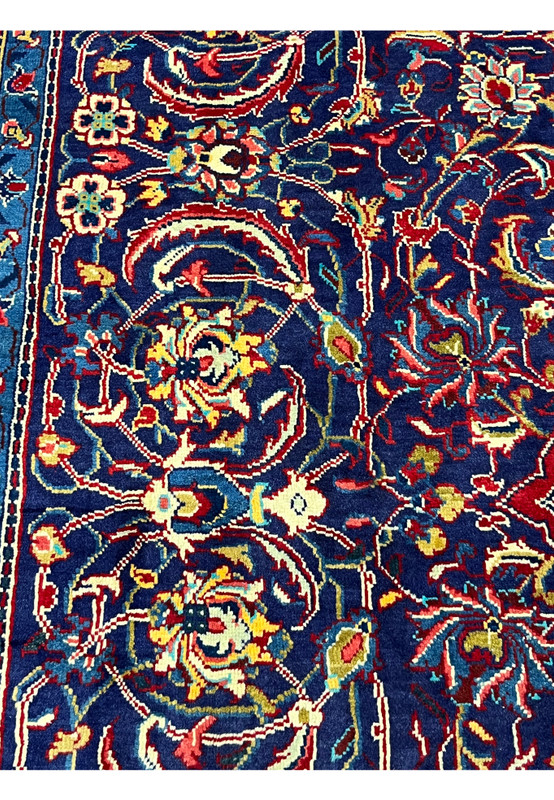 Navy ground close-up of Mahal rug, curling leaves and red blossoms with teal accents, wool pile