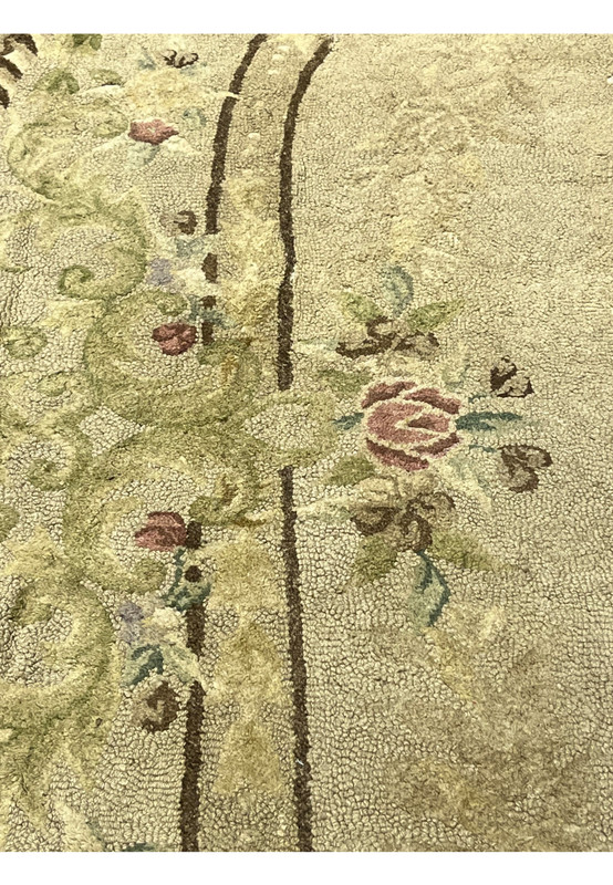 Trailing floral vine and rose pattern over a muted ground, decorative antique hand-hooked oval area rug