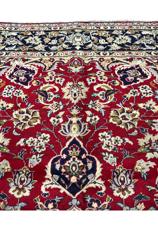 Upper border and field showing navy palmette transition into red allover floral, traditional Persian Najafabad rug