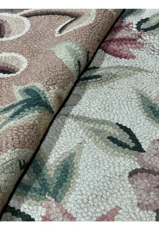 Folded hand-hooked rug revealing the thick looped wool pile and its plush cushioned surface