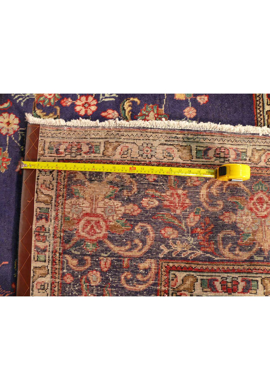 Reverse of the Tabriz rug with a tape measure across the knots showing the fine hand-knotted weave