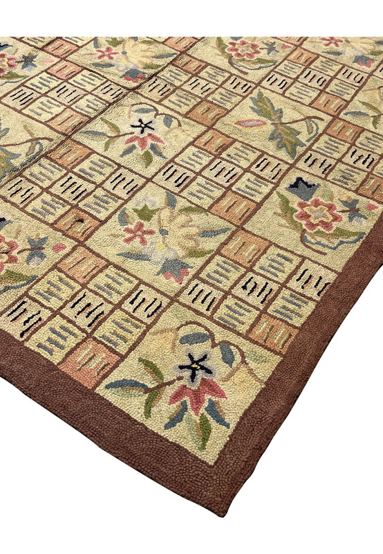 Living room ready hooked area rug corner showing dense loops and rich brown framing