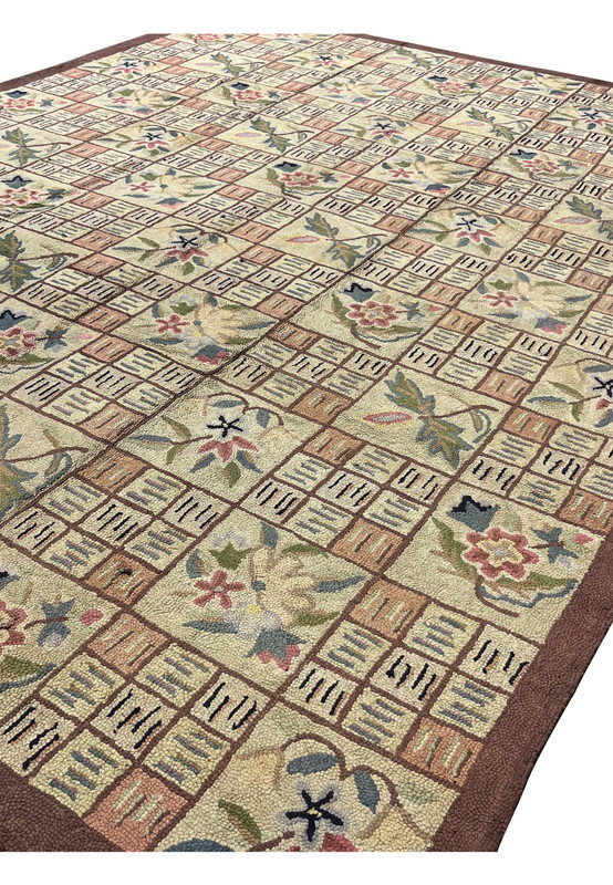 Angled view across the 9x12 patchwork rug highlighting cream salmon and sage green tiles