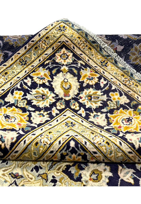 Back corner of the hand-knotted Kashan folded over showing the fine weave and cotton fringe