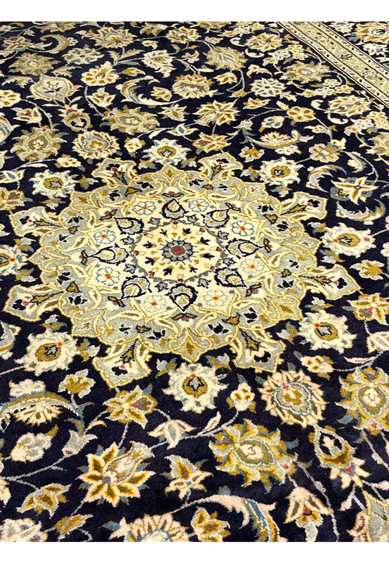 Close view of the ivory and powder blue star medallion floating on the navy Kashan field