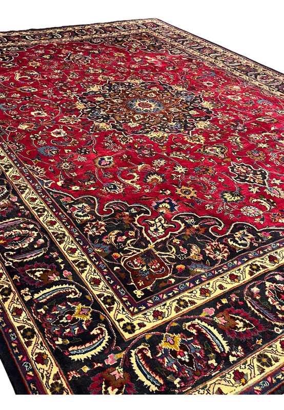 Angled view across the red field highlighting allover palmettes and the brown medallion